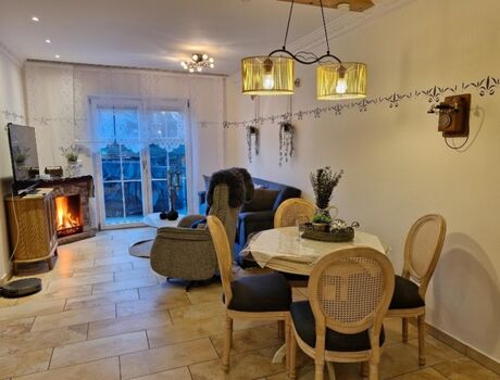 „5? Landhaus-Idylle: Offener Wohnbereich mit E-Kamin und mediterranem Flair.“