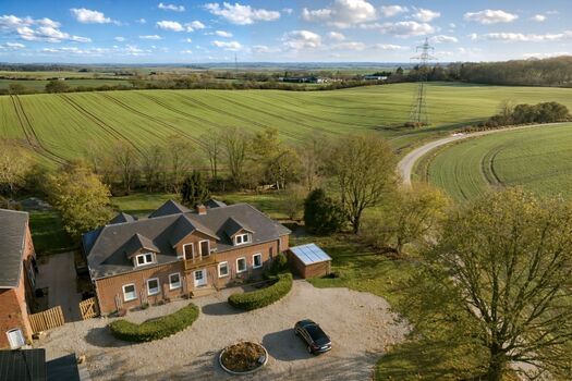 Luftaufnahme Ferienhaus, eingebettet in die hügelige Landschaft