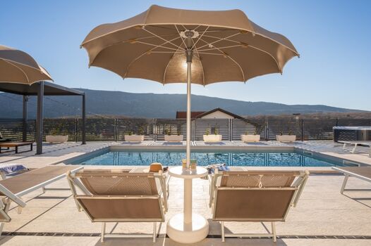 Cozy Lounge area surrounded by sun loungers, a relaxing Jacuzzi, and an outdoor shower.