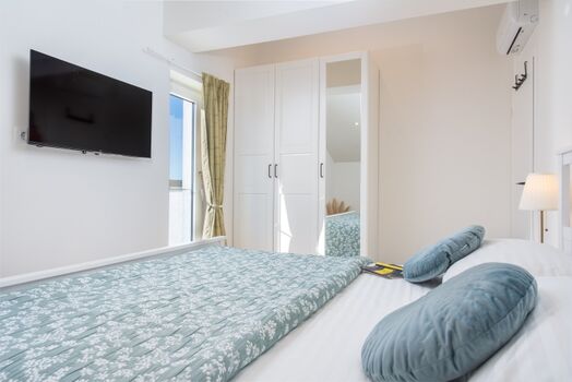 A bedroom withe king-size bed (180x200cm), TV, AC ensure restful nights.mer