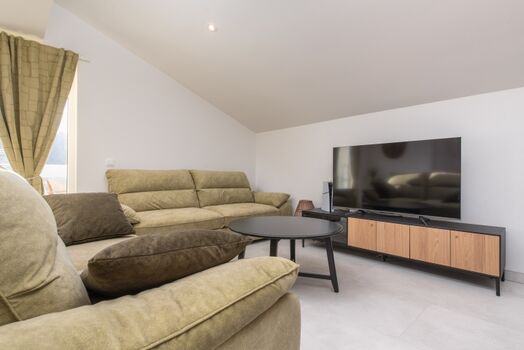 Another open-plan living area with a terrace overlooking the pool and natural surroundings, perfect for morning coffee or evening relaxation.