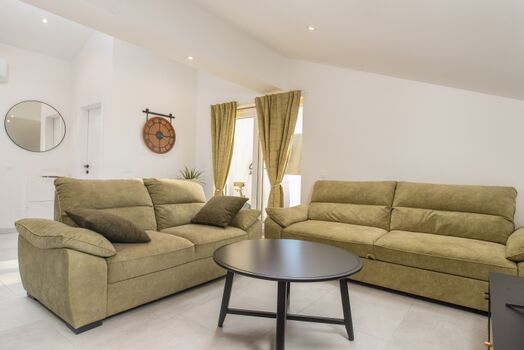 Another open-plan living area with a terrace overlooking the pool and natural surroundings, perfect for morning coffee or evening relaxation.