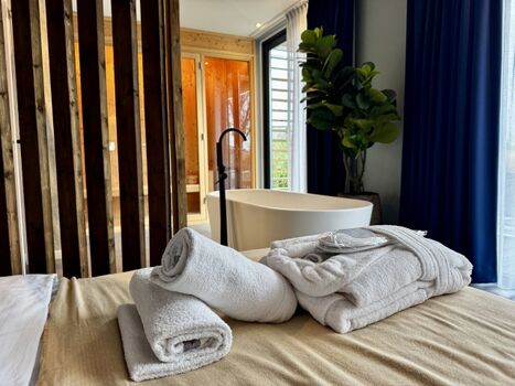 Ein Handtuchpaket mit Bademantel und Slippern wartet im Chalet