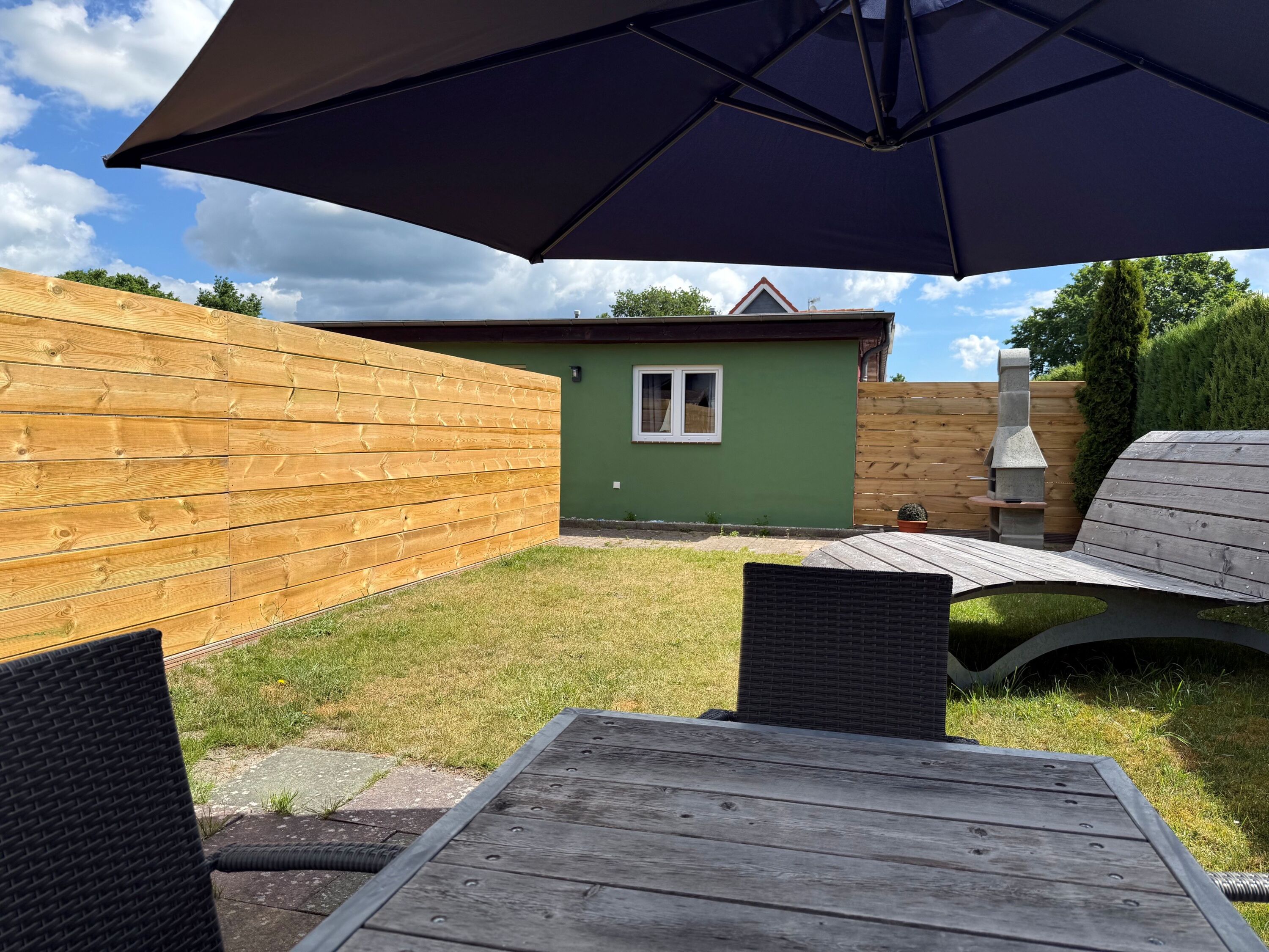 Garten mit Sonnenliege und Grillkamin