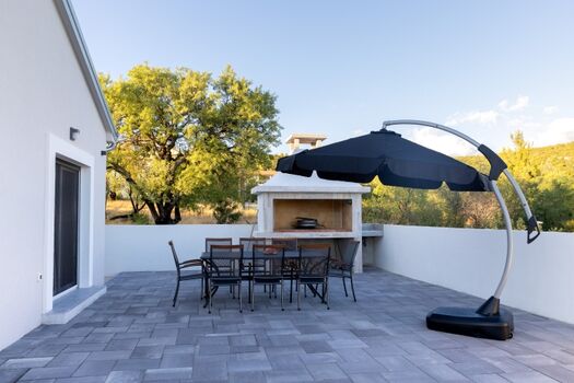 Enjoy the outdoor seating space perfect for gatherings, located right by the traditional wood-fired grill.