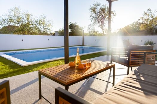 Relax in the comfortable outdoor lounge set by the pool, ideal for sipping your favorite drink and soaking up the peaceful atmosphere.