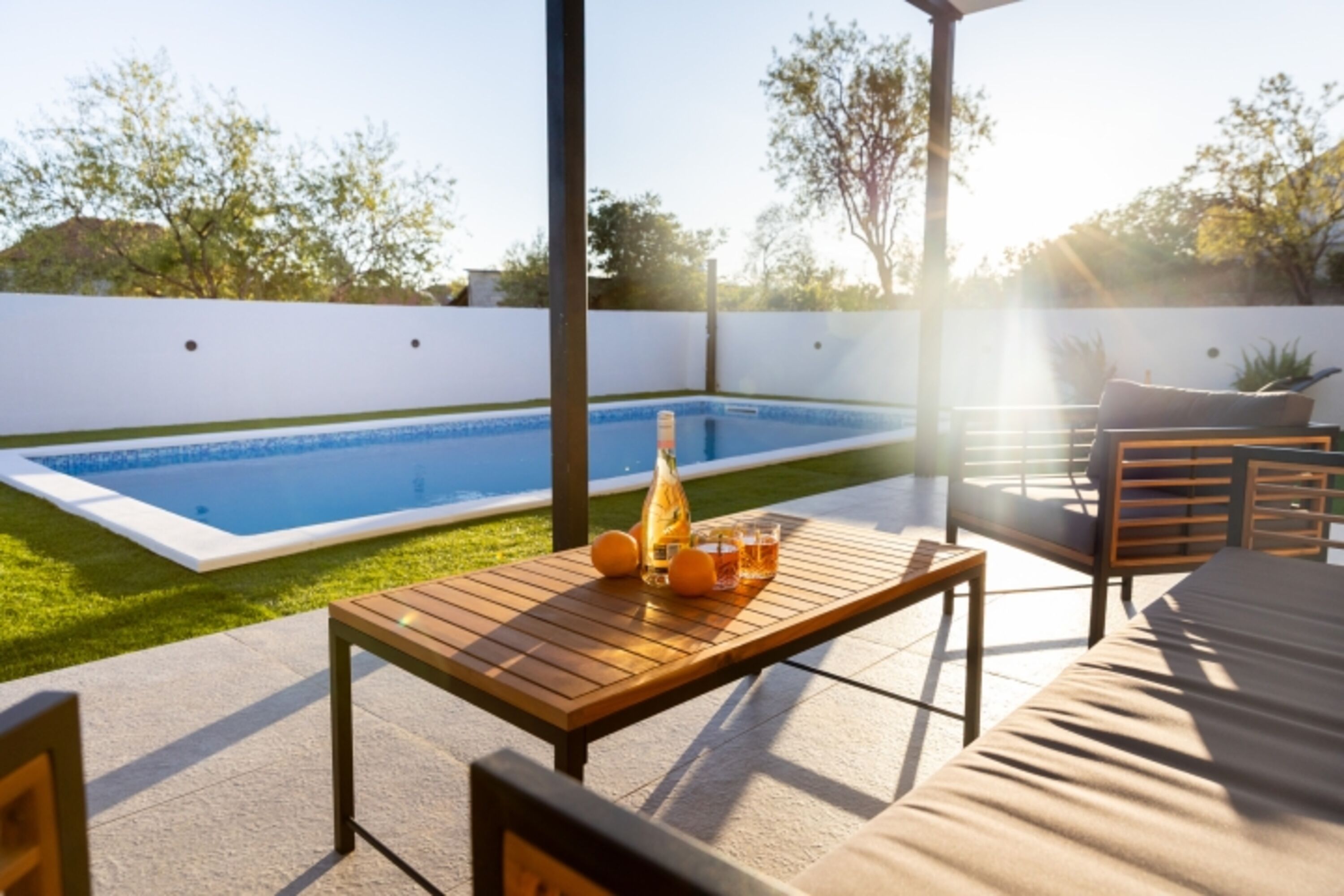 Relax in the comfortable outdoor lounge set by the pool, ideal for sipping your favorite drink and soaking up the peaceful atmosphere.