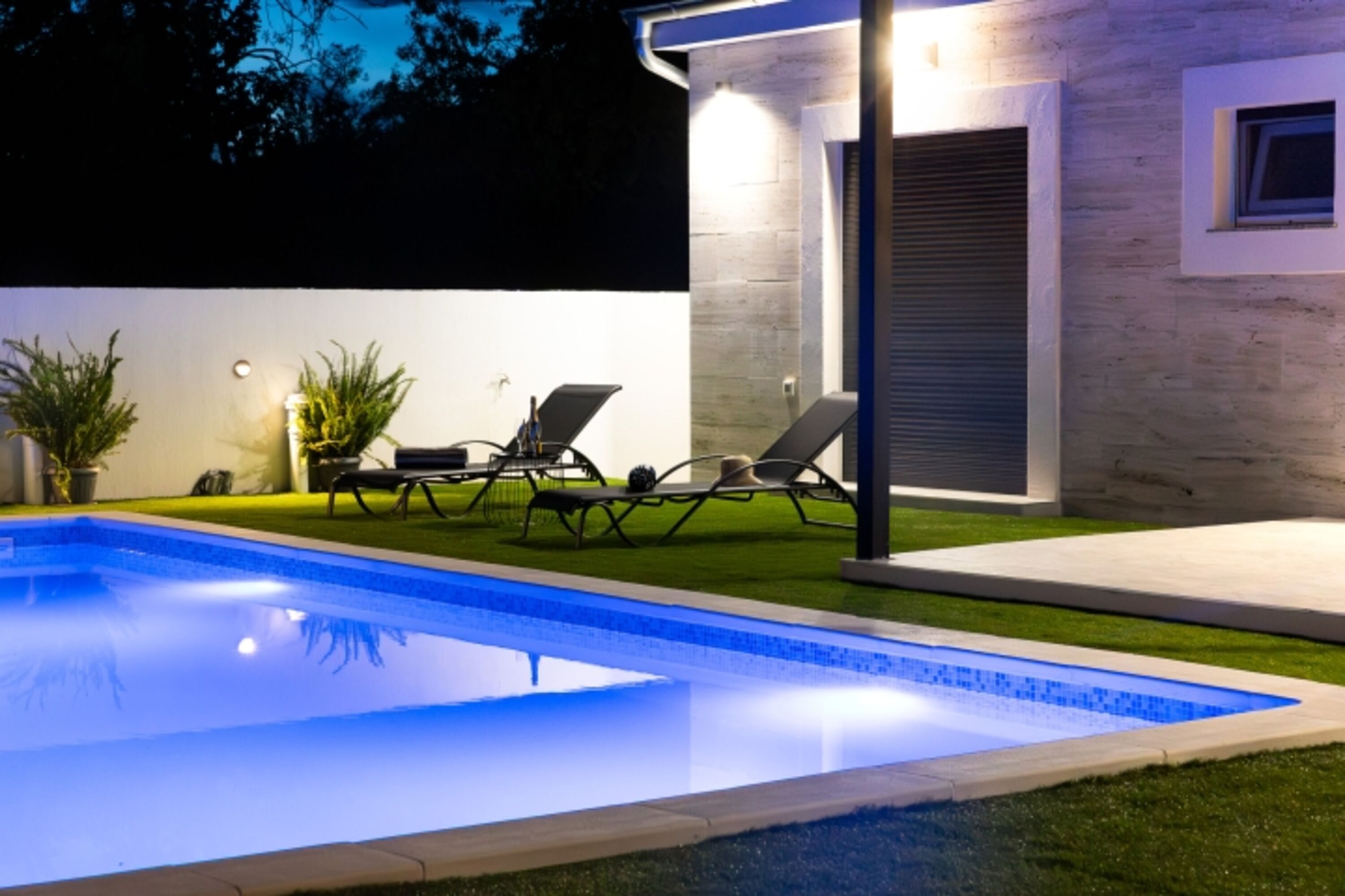 The perfect blend of a beautifully illuminated house and a sparkling pool creates an enchanting atmosphere for unforgettable evenings.