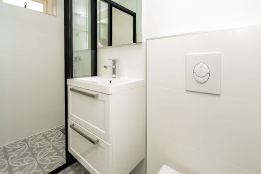 Badezimmer mit Dusche, Waschbecken und Toilette