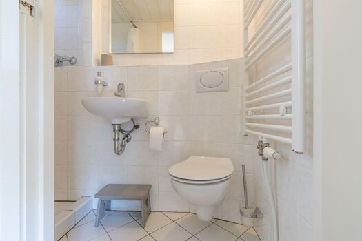 Badezimmer mit Dusche, Waschbecken und Toilette