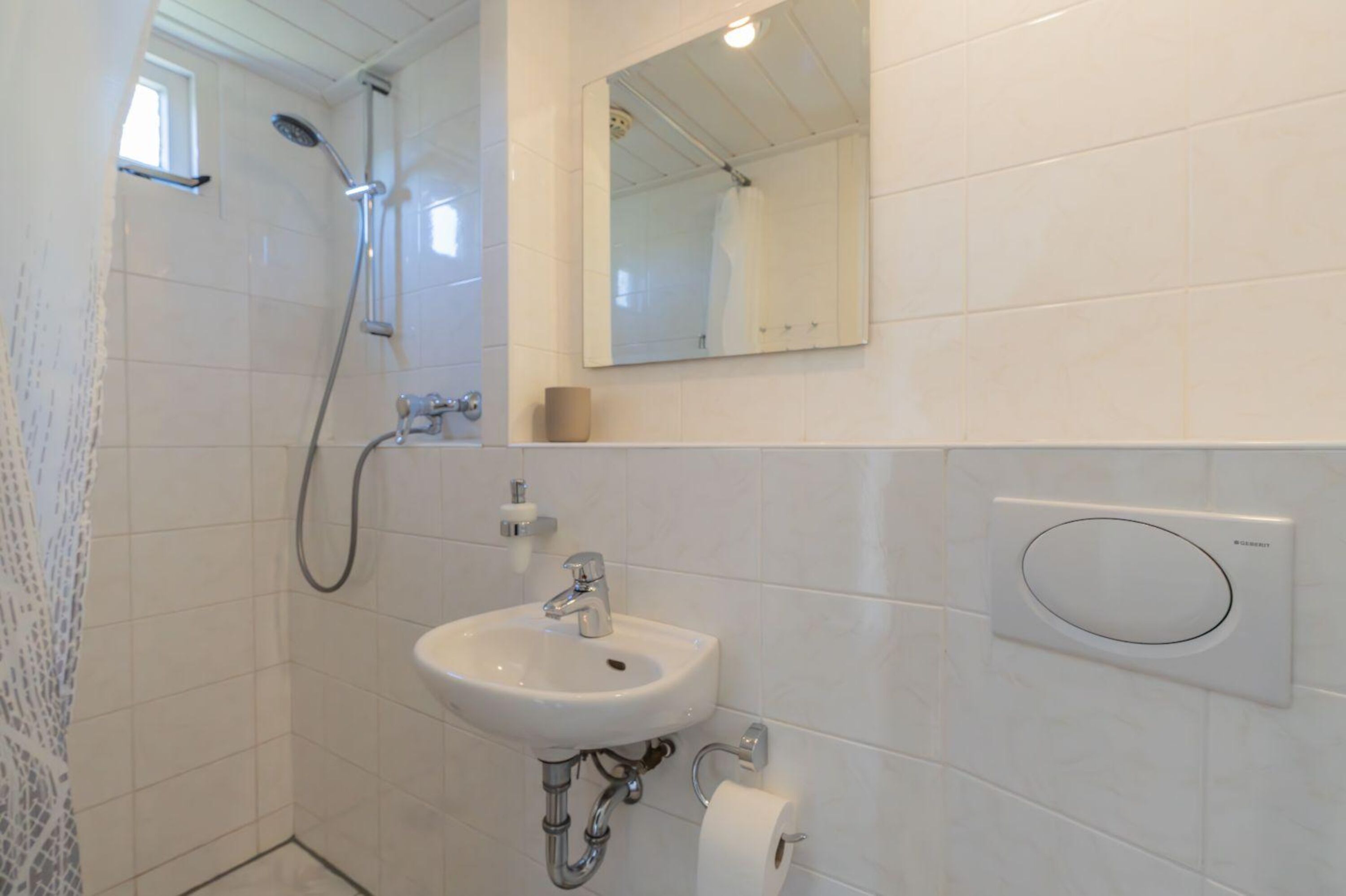 Badezimmer mit Dusche, Waschbecken und Toilette
