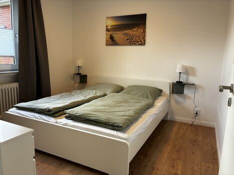 Schlafzimmer mit Doppelbett und Smart-TV