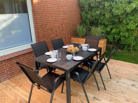 Terrasse mit Esstisch und Zugang zum Garten