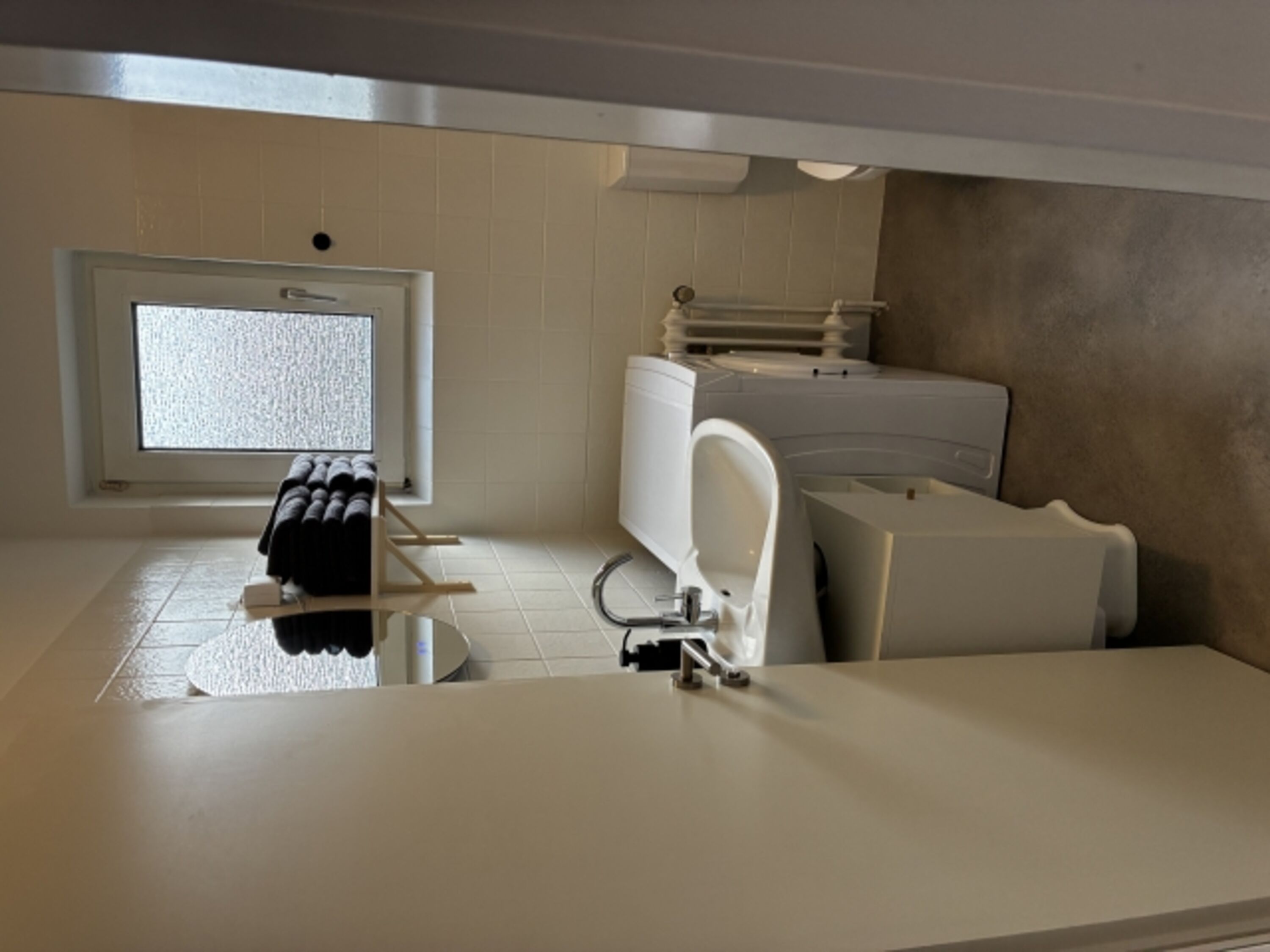 Badezimmer mit Dusche, Waschbecken und Spiegel
