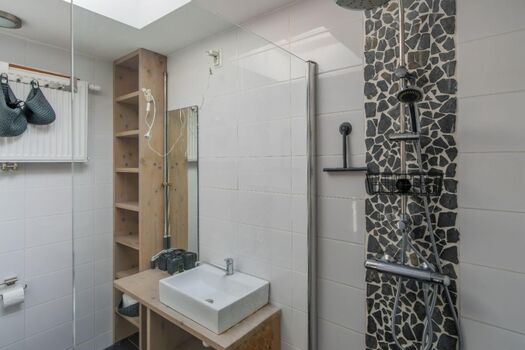 Badezimmer mit Dusche, Waschbecken und Toilette