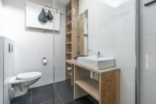 Badezimmer mit Dusche, Waschbecken und Toilette