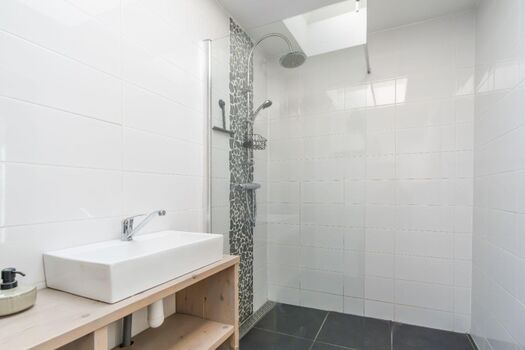 Badezimmer mit Dusche, Waschbecken und Toilette