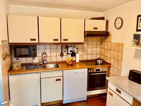 Küchenzeile mit Herd, Kühlschrank und Spülmaschine