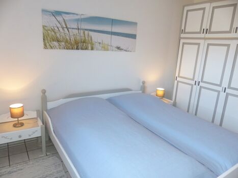 Schlafzimmer mit Doppelbett und Schrank