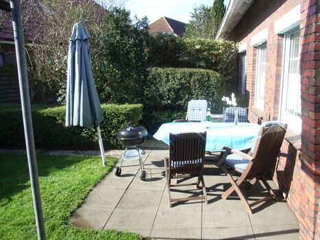 Terrasse mit Holzmöbeln und Grill