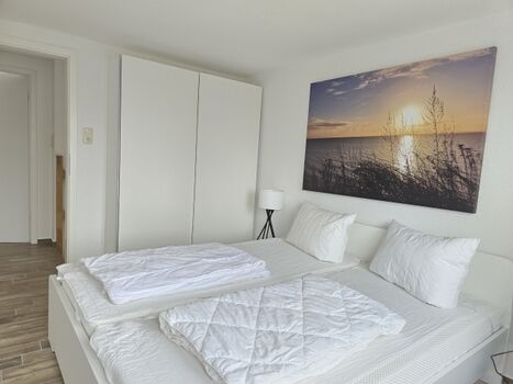 Schlafzimmer mit Doppelbett und TV