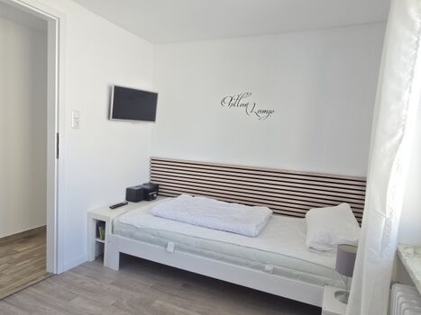 Schlafzimmer mit zwei Einzelbetten und TV