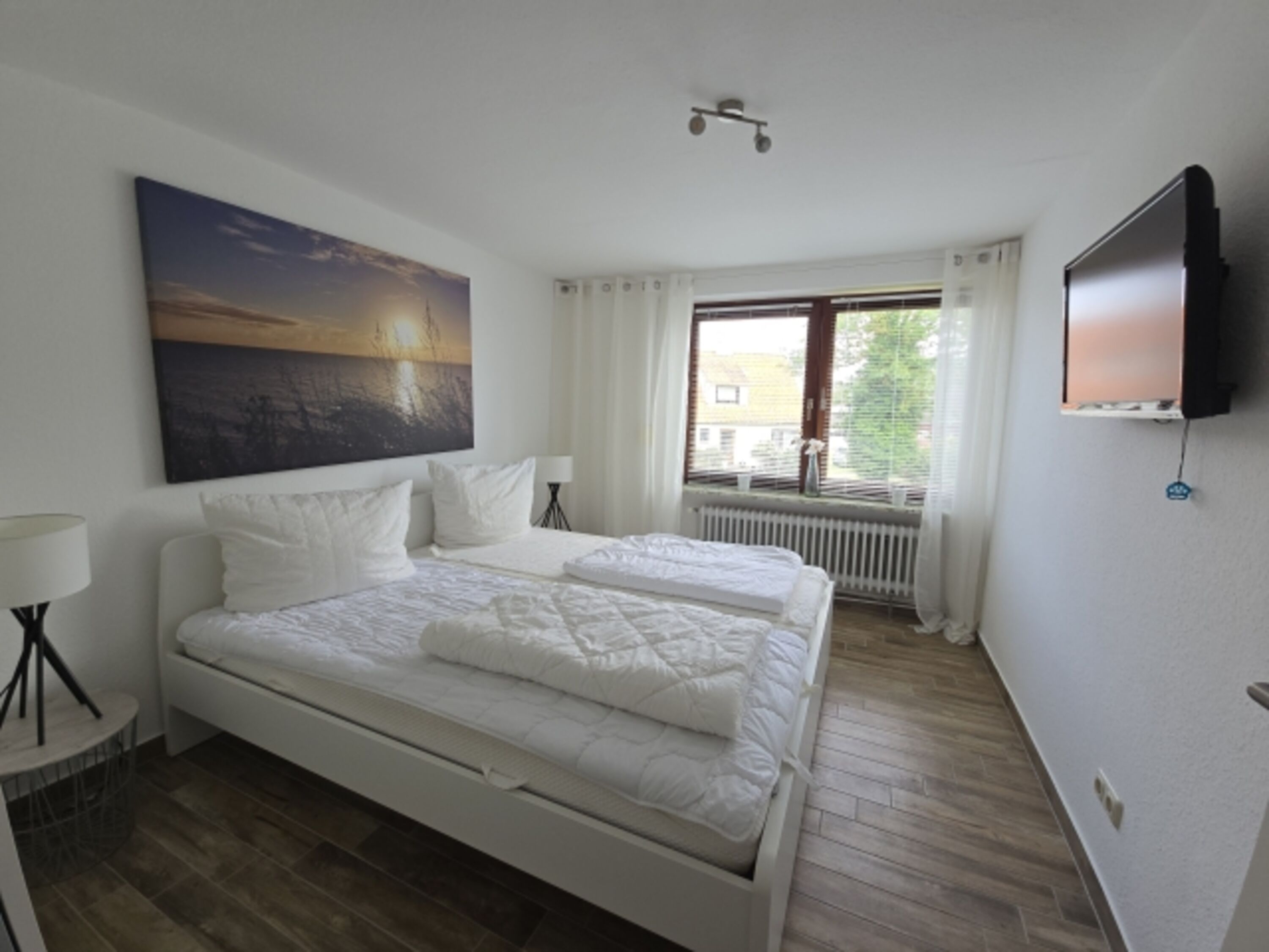 Schlafzimmer mit Doppelbett und TV