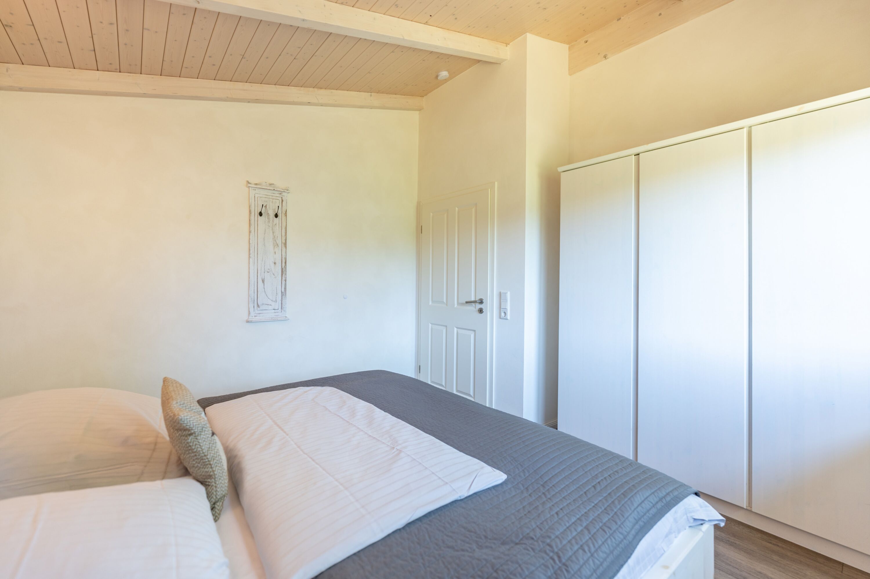 Ferienhaus Süderoog – Helles Schlafzimmer mit Doppelbett und großem Kleiderschrank