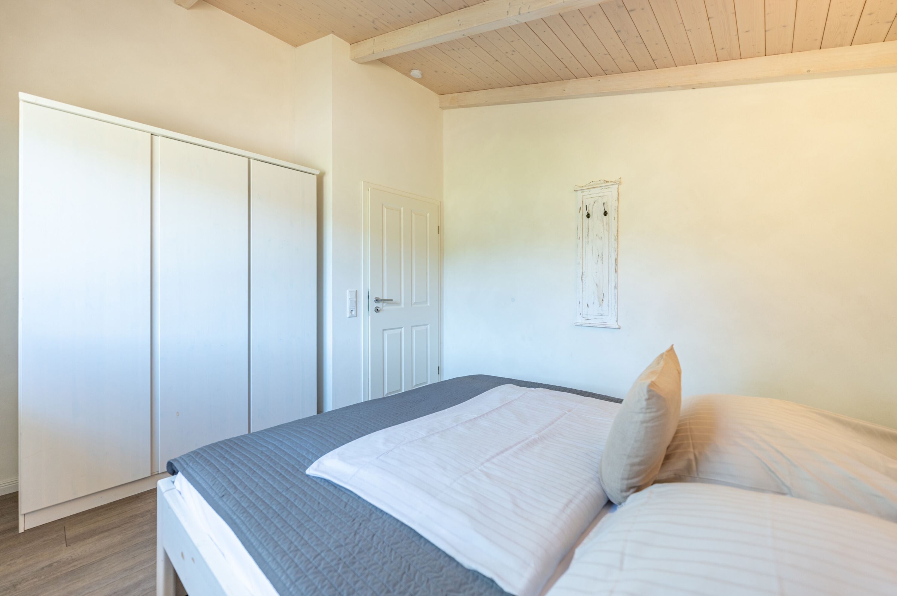 Ferienhaus Süderoog – Geräumiges Schlafzimmer mit Doppelbett und großem Kleiderschrank