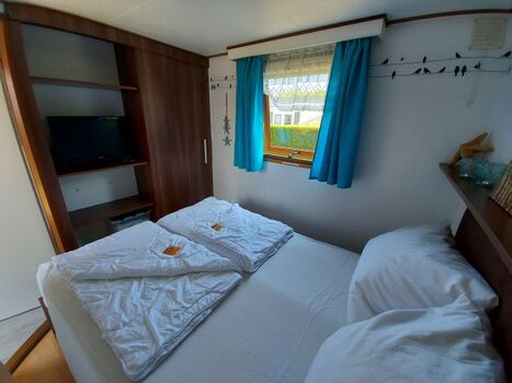 Schlafzimmer mit Doppelbett und Sat-TV