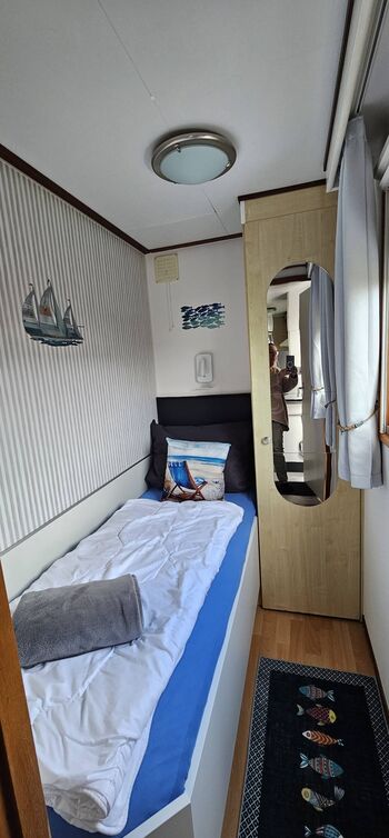 Einzelschlafzimmer mit Leselampe und Insektenschutz sowie Verdunkelungsrollo