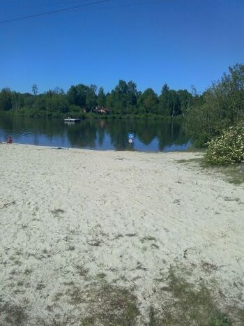 Blick über den Badesee mit Schwimminsel