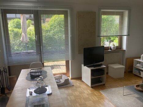 Wohnzimmer mit Küchentisch und Tür zur Terrasse