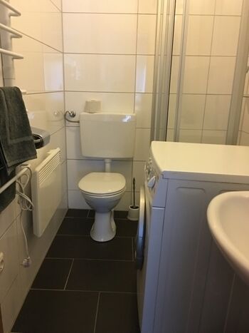 Daneben liegendes Bad mit Waschmaschine