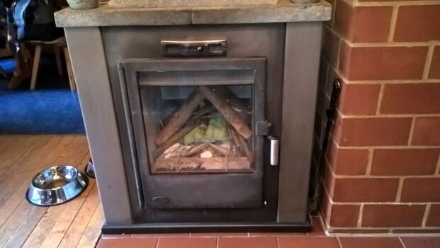 Gemütlicher Holzkamin mit Feuerschutztüre