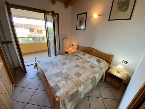 Das Schlafzimmer mit Doppelbett und verglaster Aussenterrasse