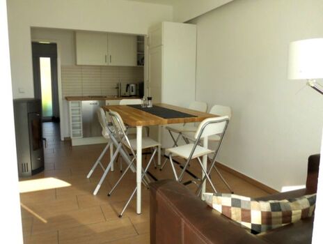 Wohnraum mit Kamin und integrierter Küche und Esstisch