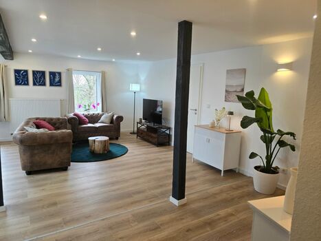 Gemütliches Wohnzimmer mit Couch und elektrischem Kamin