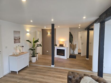 Gemütliches Wohnzimmer mit Couch und elektrischem Kamin