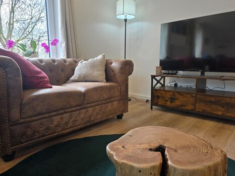 Gemütliches Wohnzimmer mit Couch und elektrischem Kamin