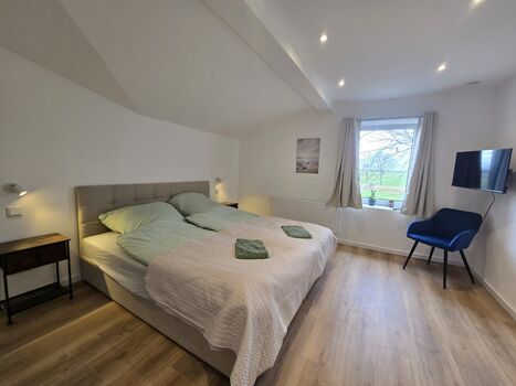 Gemütliches Schlafzimmer mit Bett, TV, Kleiderschrank