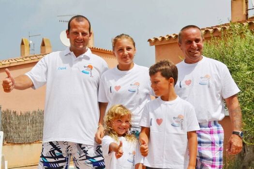 Glückliche Urlauber-Familie nach dem Sektempfang