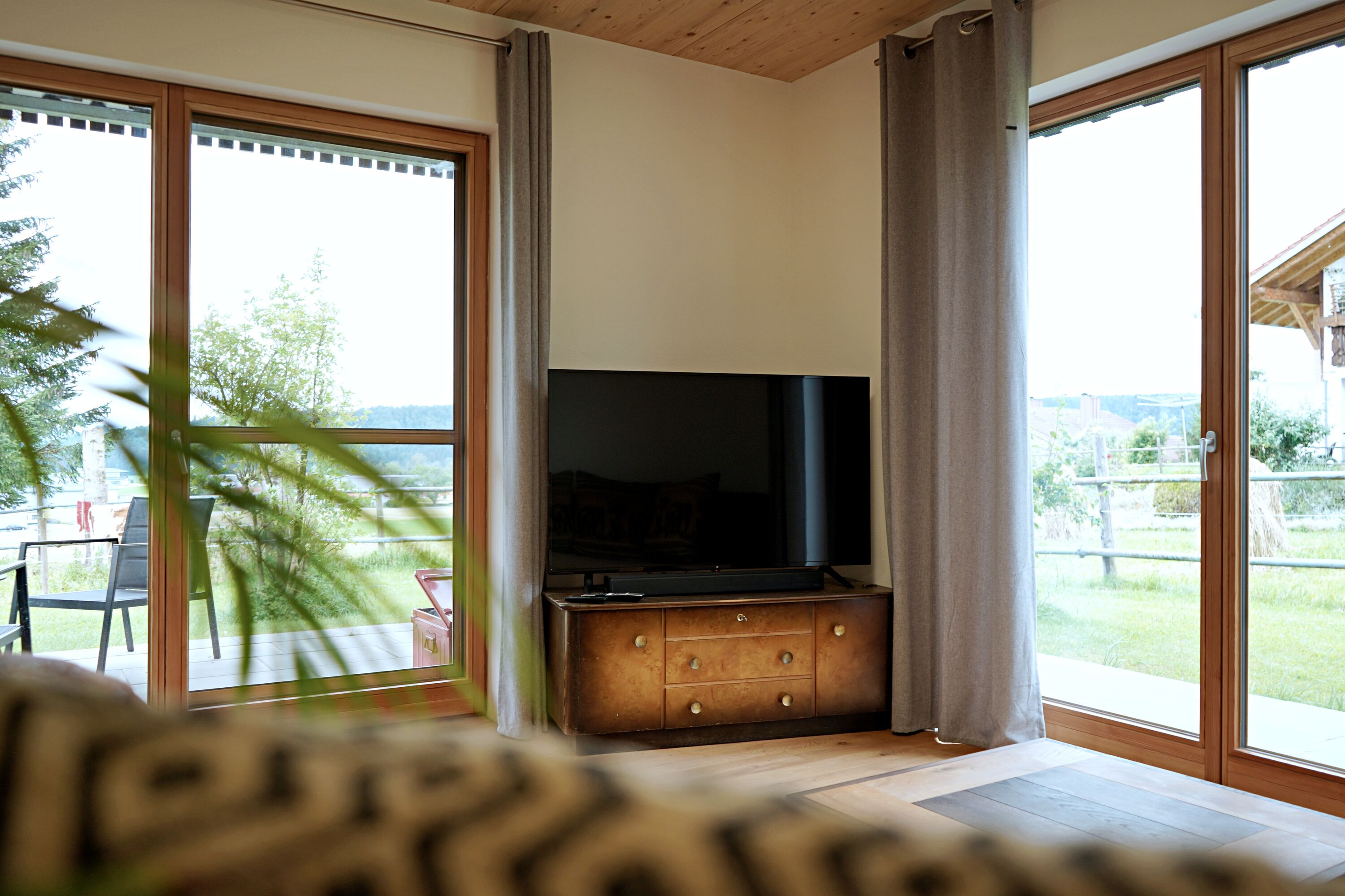 Couch mit TV und Blick auf die Terrasse
