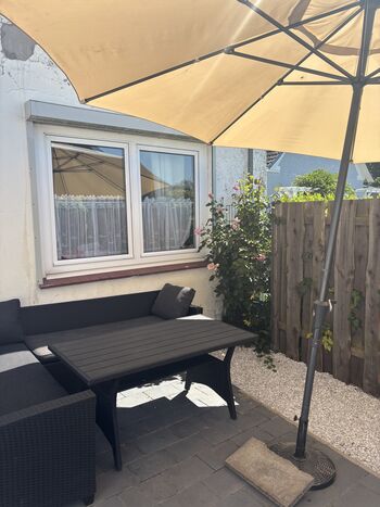 In der Sonne auf der umzäunten Terrasse die Zeit mit dem Hund genießen