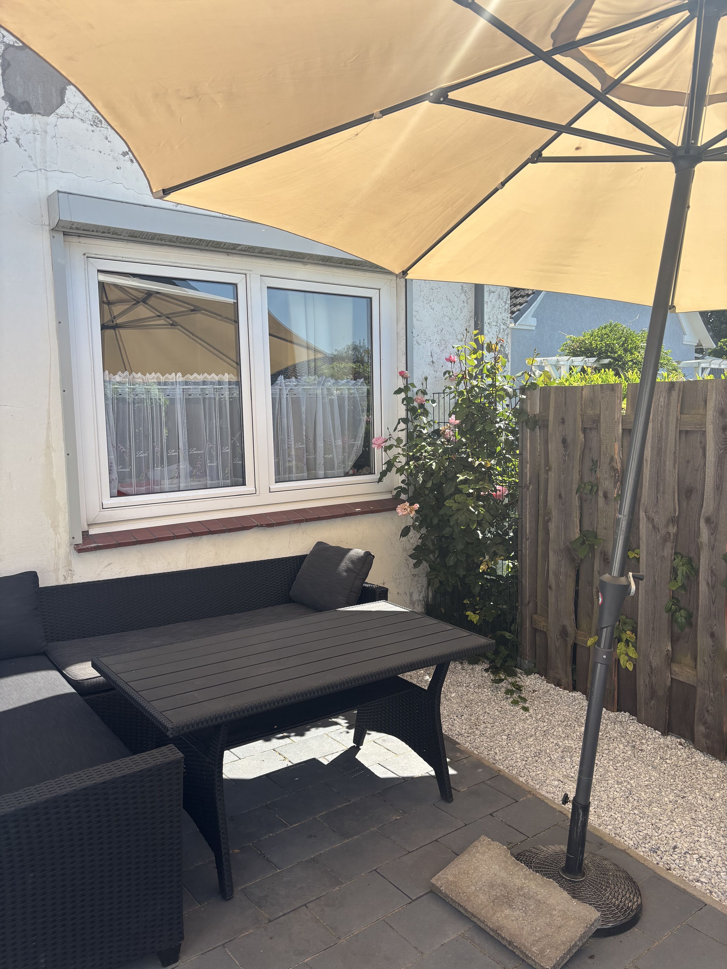 In der Sonne auf der umzäunten Terrasse die Zeit mit dem Hund genießen