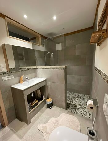 Modernes Wellness-Bad mit ebenerdiger Dusche für komfortablen Einstieg und hochwertigem Waschtisch