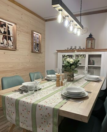 "Massiver Esstisch vor uriger Zirbenholz-Wand. Der ideale Ort für gesellige Abende oder die Planung der nächsten Wandertour durch den Bayerischen Wald."