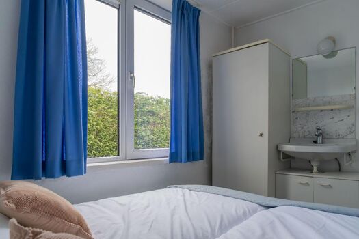 Schlafzimmer 1 mit 2 Einzel-Boxspringbetten, Kleiderschrank und Waschbecken