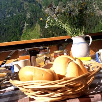 Frühstück auf dem Balkon des Ferienhauses Mildner - frische Brötchen und ein ruhiger Morgen mit Blick auf die beeindruckende Bergwelt von Heiligenblut