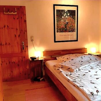 Das Schlafzimmer im waren Abendlicht mit sanfter Beleuchtung-eine ruhige, behagliche Atmosphäre, die Erholung und Schlafqualität in den Mittelpunkt stellt.